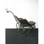 A Victorian iron framed three wheel bath chair with button back seat,