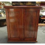 Circa 1860 a rosewood table top cabinet the two doors opening to reveal a single drawer and shelf