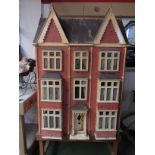 A 24" tall mid 19th Century wooden construction front opening three storey dolls house with a good