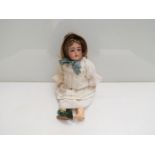 A bisque head, composition jointed Kammer & Reinhardt girl doll in bonnet and green shoes,