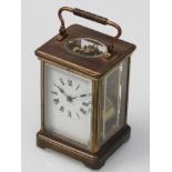 An early 20th Century French brass striking carraige clock with white enamel face, Roman numerals,