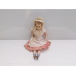 A 17" composition head girl doll in check dress with apron,