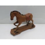 A late 19th early 20th Century toy horse standing on platform four wheels,