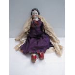 A 24" tall mid 19th Century glazed porcelain head doll, wearing purple dress,