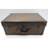 An early 20th Century Louis Vuitton suitcase with original leather banding and locks,