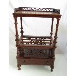A mid Victorian walnut Canterbury with pierced three quarter gallery over turned supports,