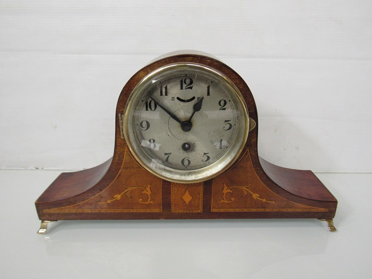 A mahogany and inlaid Napoleon hat form mantel clock with drum movement, Arabic silvered dial, key,