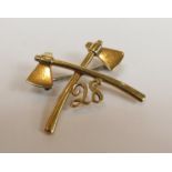 A yellow metal crossed axes military badge with No.