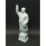 A white china figure of Chairman Mao with raised hand