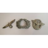 A German aluminium police cap badge of eagle and wreath form,