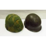 A US Army front seamed helmet together with a later example with camouflage cover (2)