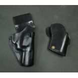 Two black leather pistol holsters: Ruger GP100 and another