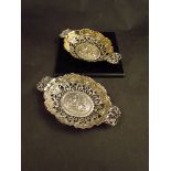 A near pair of William Comyns bon-bon dishes with embossed and floral detail, twin cherub handles,