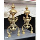 A Georgian pair of brass fire dogs with bulbous finial's and mask to front