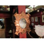 An Arts and Crafts copper mirror with three coat hooks