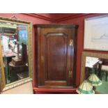 A George III mahogany crossbanded oak single door corner cupboard (with key)