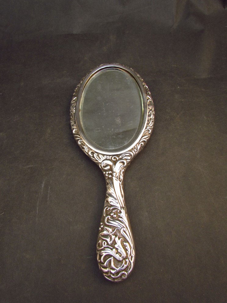 A silver embossed hand mirror with bug, foliate and figural design, - Image 2 of 2