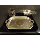 A silver tray with Churchill head coin to centre, an Oriental napkin ring and a silver tea strainer,