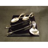 A pair of silver sugar tongs, two silver feeding spoons and a silver caddy spoon,