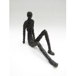 An Alberto Giacometti style sculpture of a seated figure, signed to base 'Mendes'.