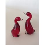 Two Whitefriars 'Dilly' ducks in ruby glass with bubble inclusions.