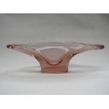 A large pink glass bowl of elongated form. (chip to one side) 15cm high x 13.