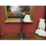 An iron frame table lamp of column form with milk glass stepped shade,