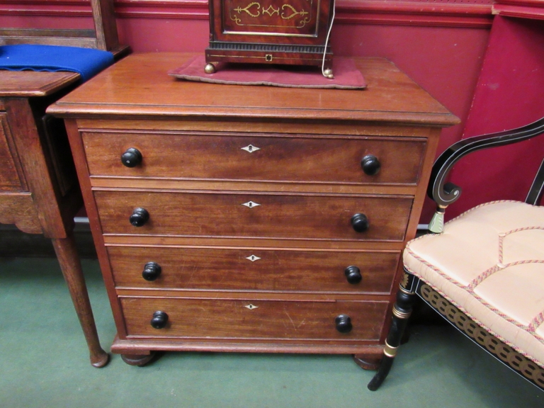 A George III mahogany chest of four graduated drawers of diminutive size,