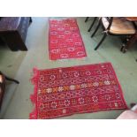Two red ground rugs with aztec design and tasselled ends