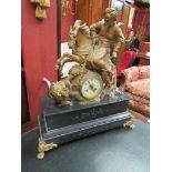 A late 19th Century French figural mantel clock surmounted by horse and rider hunting a lion black