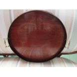 An Edwardian mahogany and inlaid circular galleried tray with brass twin handles,