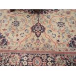 A gold ground wool rug with central floral motif multiple borders,