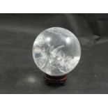 A Brazilian quartz sphere on wooden stand,