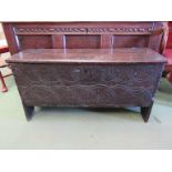 A 17th Century six plank oak coffer with carved lunette frieze, top split,