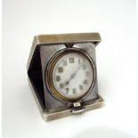 A silver travel watch in engine turned case,