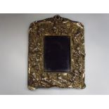 A Britannia silver easel back photograph framed, heavily embossed with cherubs, vines,