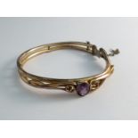 A stiff hinge bangle set with amethyst a/f