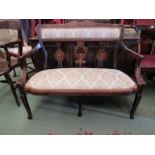 A late Victorian inlaid mahogany two seater sofa the pierced splats and scroll arms over a bow