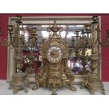 A 20th Century cast brass French clock with candlestick garniture,