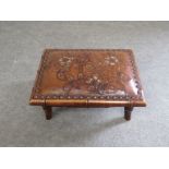 Attributed to Liberty & Co an Arts and Crafts walnut footstool the floral embossed polychrome