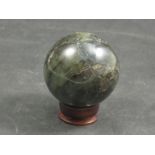 A Madagascan Labradorite sphere on wooden stand,