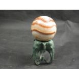 A Rainbow Jasper Australian sphere on cast metal elephant stand