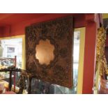A decorative carved Indian hardwood panel with vacant central cartouche, high relief, flowers,