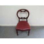 A set of four William IV mahogany dining chairs with scroll backs red faux leather seats inverted