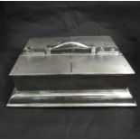 A silver humidor of large proportions with four lift top engine turned hinged compartments,
