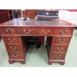 An early 20th Century Georgian style mahogany twin pedestal desk of nine drawers with tooled