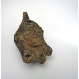 A terracotta oil lamp as a bearded face,