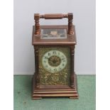 A late Victorian brass cased carriage clock, with black Arabic numerals to the cream chapter ring,