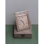 A cased Art Deco 8 day Swiss travel clock with decorative engraved case,