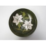 A William Moorcroft white lily design fruit bowl on green ground, paper label to base,